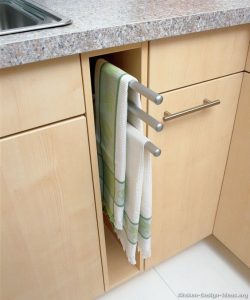 De theedoeken zijn makkelijk gepakt wanneer je ze nodig hebt maar goed verstopt in deze inham tussen de keukenkastjes, waar ze rustig kunnen drogen.